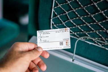 Fas 'ta yüksek hızlı bir trenin içinde elinde tren bileti olan bir adam.