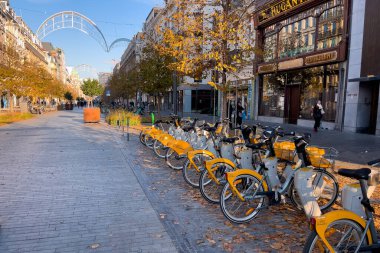 Brüksel, Belçika 'da sokakta kiralık bisiklet parkındaki sarı bisiklet sıraları.