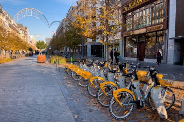Brüksel, Belçika 'da sokakta kiralık bisiklet parkındaki sarı bisiklet sıraları.