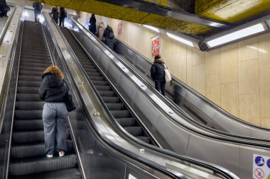 Brüksel, Belçika 'daki bir metro istasyonunda yürüyen merdivenleri kullanan insanlar.