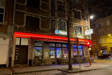 The exterior of an open coffee shop at night in Brussels, Belgium