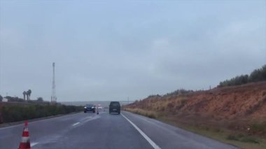 Dashcam view of a car driving on the highway during a rainy day in Morocco