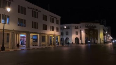 Cars driving on the road at night nearby The Bank Al Maghrib (Moroccan Central Bank) on Avenue Mohammed V in Rabat, Morocco