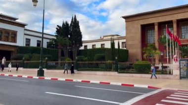 People walking by the Moroccan Parliament building in Rabat, Morocco