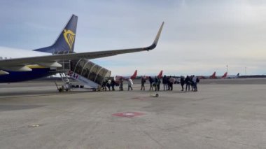 Passengers boarding a Ryanair commercial airplane at Milan Malpensa Airport in Italy