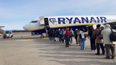 Passengers boarding a Ryanair commercial airplane at Milan Malpensa Airport in Italy