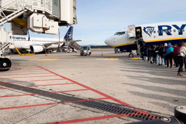 Passengers boarding a Ryanair commercial airplane at Milan Malpensa Airport in Italy