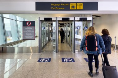 People walking towards the luggage reclaim area at Brussels airport in Belgium