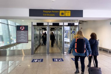 People walking towards the luggage reclaim area at Brussels airport in Belgium