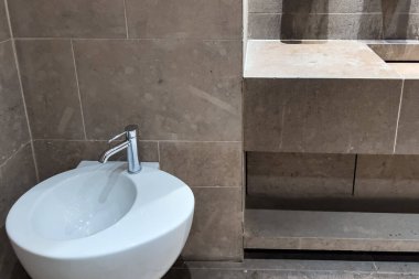 Row of automated silver taps inside a modern public bathroom