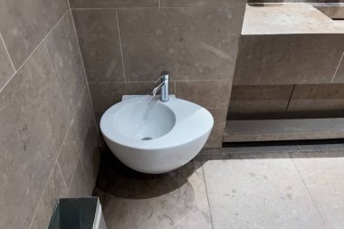 Row of automated silver taps inside a modern public bathroom