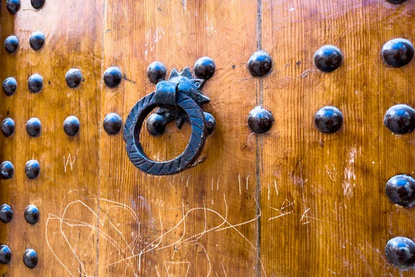 Vintage metal door knocker on a wooden Arabian door in Morocco