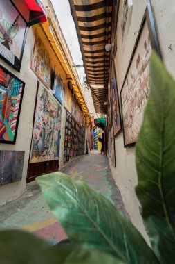 The popular colorful street in the old town of Fes with paintings hanging on the walls