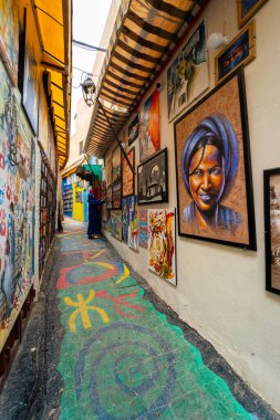 The popular colorful street in the old town of Fes with paintings hanging on the walls