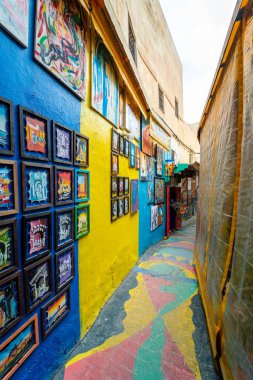 The popular colorful street in the old town of Fes with paintings hanging on the walls
