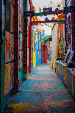 The popular colorful street in the old town of Fes with paintings hanging on the walls