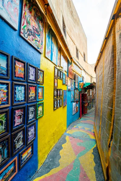 stock image The popular colorful street in the old town of Fes with paintings hanging on the walls