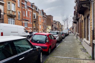 Arabalar Brüksel, Belçika 'da boş bir caddenin kenarına park edilmiş.
