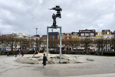 Belçika, Gent 'teki Koningin Maria Hendrikaplein heykelinin yakınında yürüyen insanlar.