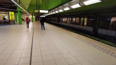 İnsanlar Brüksel, Belçika 'da metro istasyonunda metro bekliyor.