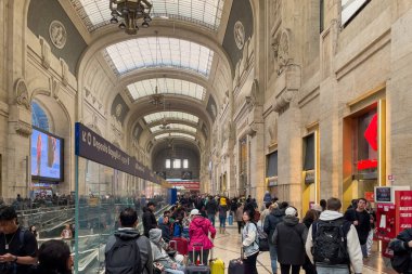 İtalya 'daki Milano Merkez Tren İstasyonu' nda yürüyen bir grup yolcu.