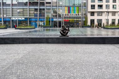 Bratislava, Slovakya 'daki Eurovea alışveriş merkezinin önündeki çeşmenin kenarında oturan kişinin bronz heykeli