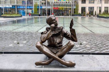 Bratislava, Slovakya 'daki Eurovea alışveriş merkezinin önündeki çeşmenin kenarında oturan kişinin bronz heykeli