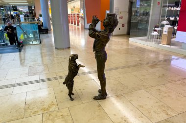 Bratislava, Slovakya 'daki Eurovea alışveriş merkezinde bir köpek ve bir müzisyenin bronz heykelleri