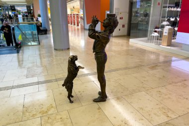 Bratislava, Slovakya 'daki Eurovea alışveriş merkezinde bir köpek ve bir müzisyenin bronz heykelleri