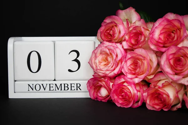 November Holzkalender Weiß Auf Schwarzem Hintergrund Rosa Rosen Liegen Daneben — Stockfoto