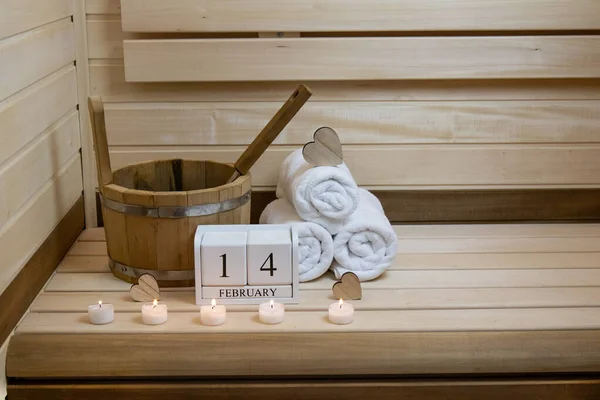 Valentines Day, sauna. February 14 calendar, candles are burning, a bucket and wooden hearts. The concept of spa, relax, rest, health, wellness, holiday, postcard, gift,poster, copy space, text