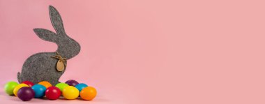  Wide Easter banner. Soft gray hare and eggs are multi-colored on a pink background.Holiday concept, congratulation, postcard, template,copy space, text, moc-up,handmade,spring,decoration,party,poster