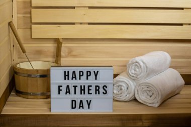 Sauna kartpostalı. Yazı, mutlu babalar günü, havlular ve tahta bir kova. Rahatlama, sağlık, mesaj, tatil, hediye, poster, tebrikler, davetiye, fotokopi alanı, yaşam tarzı, spa, baba.