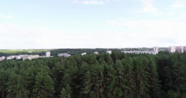 Kamera ormanın üzerine yükselir ve şehrin ortasına kurulur.