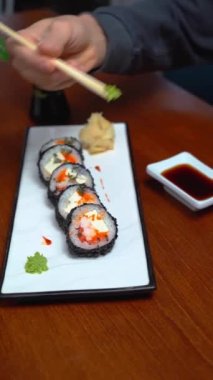 Adam restoranda tempura suşi yiyor.