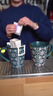 The bartender prepares coffee in bags for the client