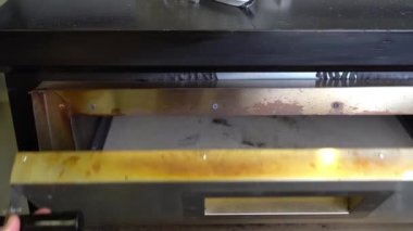 Bir şef restoranın mutfağında fırında pizza pişirir.
