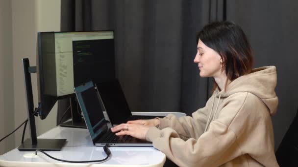 Uma Mulher Está Programando Laptop Qual Vários Monitores Estão Conectados — Vídeo de Stock