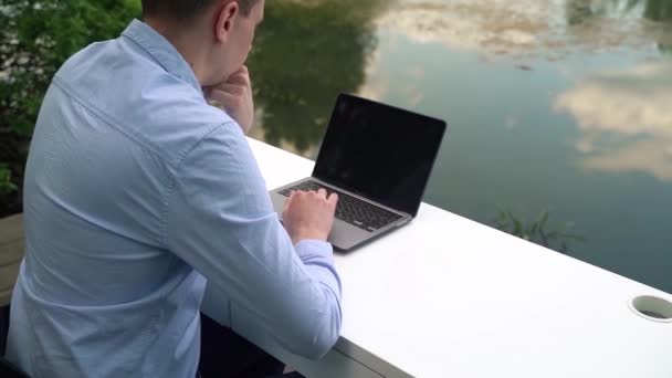 Man Arbetar Med Bärbar Dator Nära Floden — Stockvideo