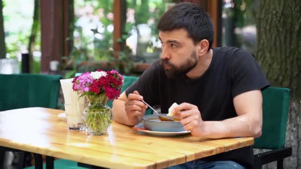 Ένας Άντρας Τρώει Μια Νόστιμη Σούπα Στη Βεράντα Ενός Εστιατορίου — Αρχείο Βίντεο