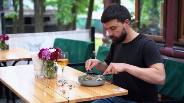 レストランでニコイスサラダを食べる男 — ストック動画