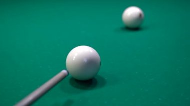 Bir adam bilardo topuna vurup diğerini vuruyor ve topu cebine atıyor.