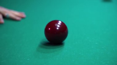 Yakın plan adam kırmızı bilardo topuna vuruyor.