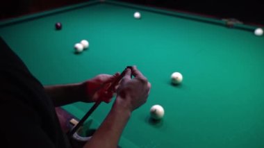 Yakın çekim adamı bilardo ıstakasını temizliyor.