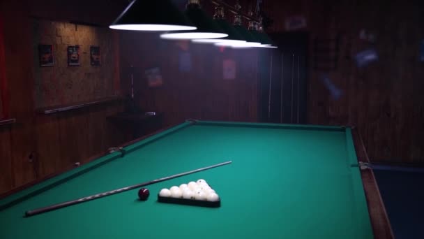 在游泳池俱乐部里拍摄的大气镜头 相机放大了游泳池桌子上的镜头 桌子后面站着一个拿着球杆的男人 — 图库视频影像