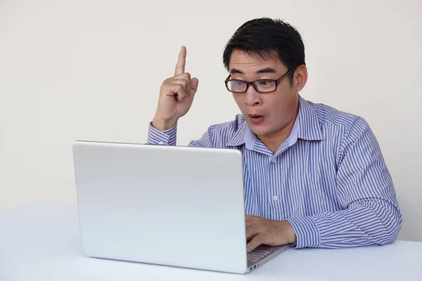 ハンサムなアジアの男のオフィスの労働者は驚きを感じ ノートパソコンのコンピュータでインターネットをサーフィン中にアイデアを得た 指を上げて コンセプト オンラインで動作します 日常生活デジタル テクノロジースマートデバイス — ストック写真