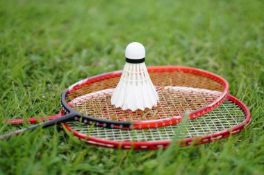 Badminton shuttlecock and racket on grass floor. Concept : Sport with equipment, workout. Recreational sport that can be played for fun or exercise and competition in team or individual.