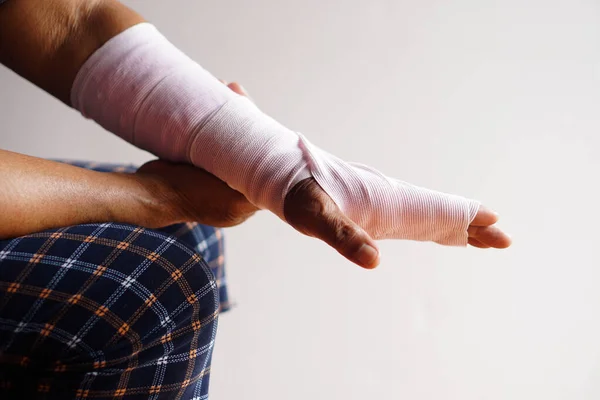 用绷带包扎在扭伤手腕上的闭合手 治疗伤害手臂 健康问题 意外事故 — 图库照片