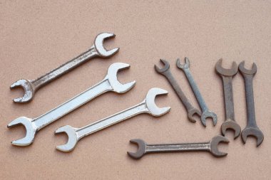 Kahverengiye izole edilmiş metal anahtarlar. Kavram, tamirci, mekanik aletler. Spanners. Tamir ve onarım için ekipman, günlük yaşamda yenileme.        