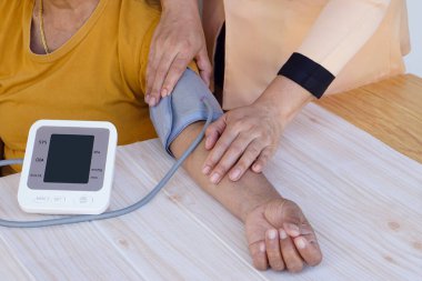 Yakın hemşire elleri kan basıncını ve kalp atış hızını ölçmek için kan basıncı monitörü kullanır. Konsept, sağlık hizmeti, hastane, klinik, doktor. Metin için boş ekran.